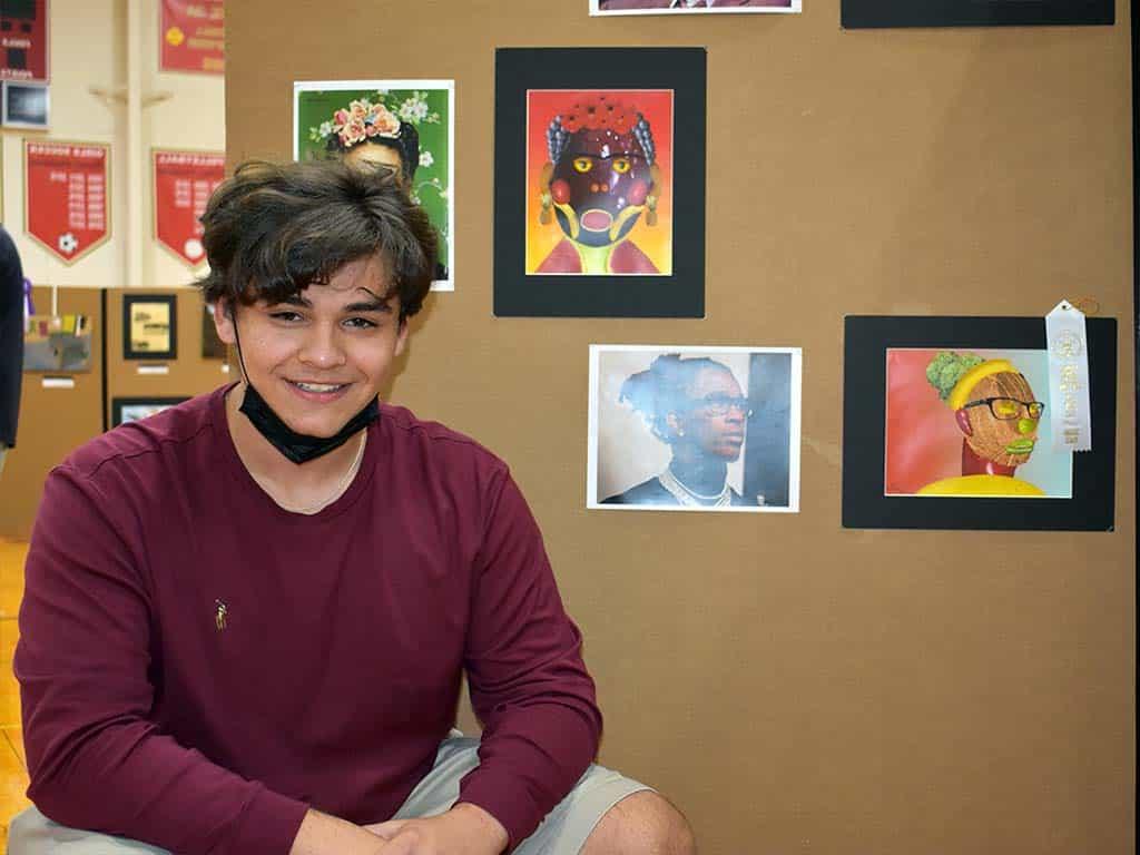 Male art student posing with art and ribbon